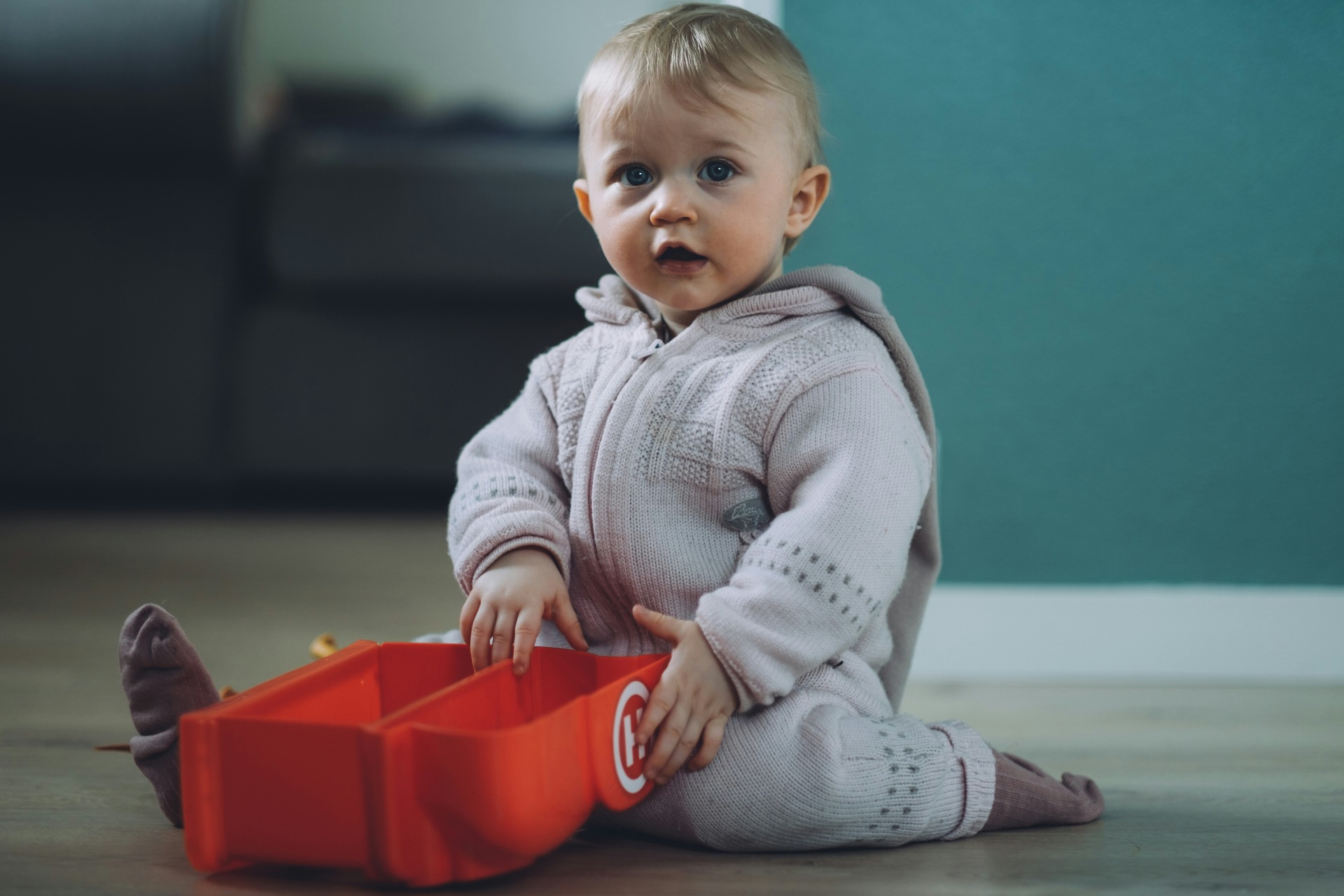 Baby playing with toy in living room.
