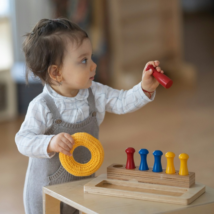 Toddler playing with colorful educational toys