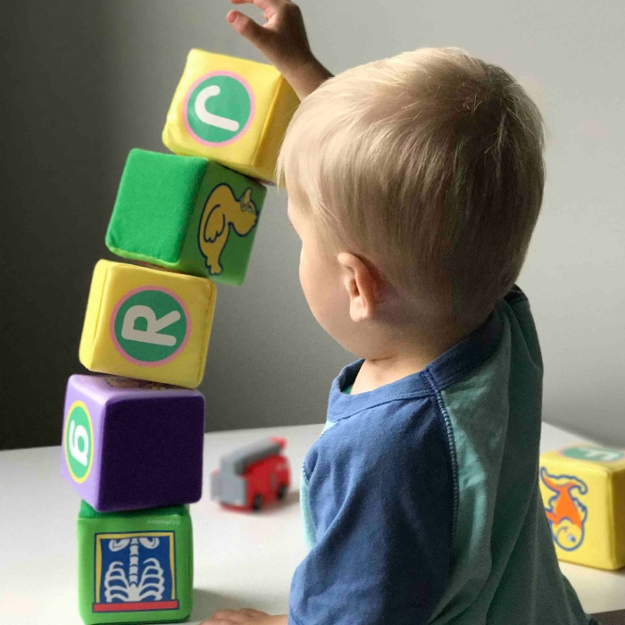 Child balancing soft blocks with precision